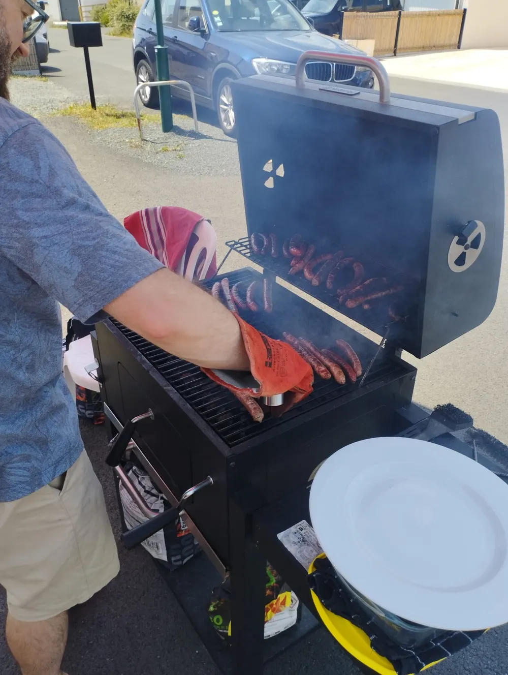 Saucisses et merguez qui grillent sur le barbecue de la fête.